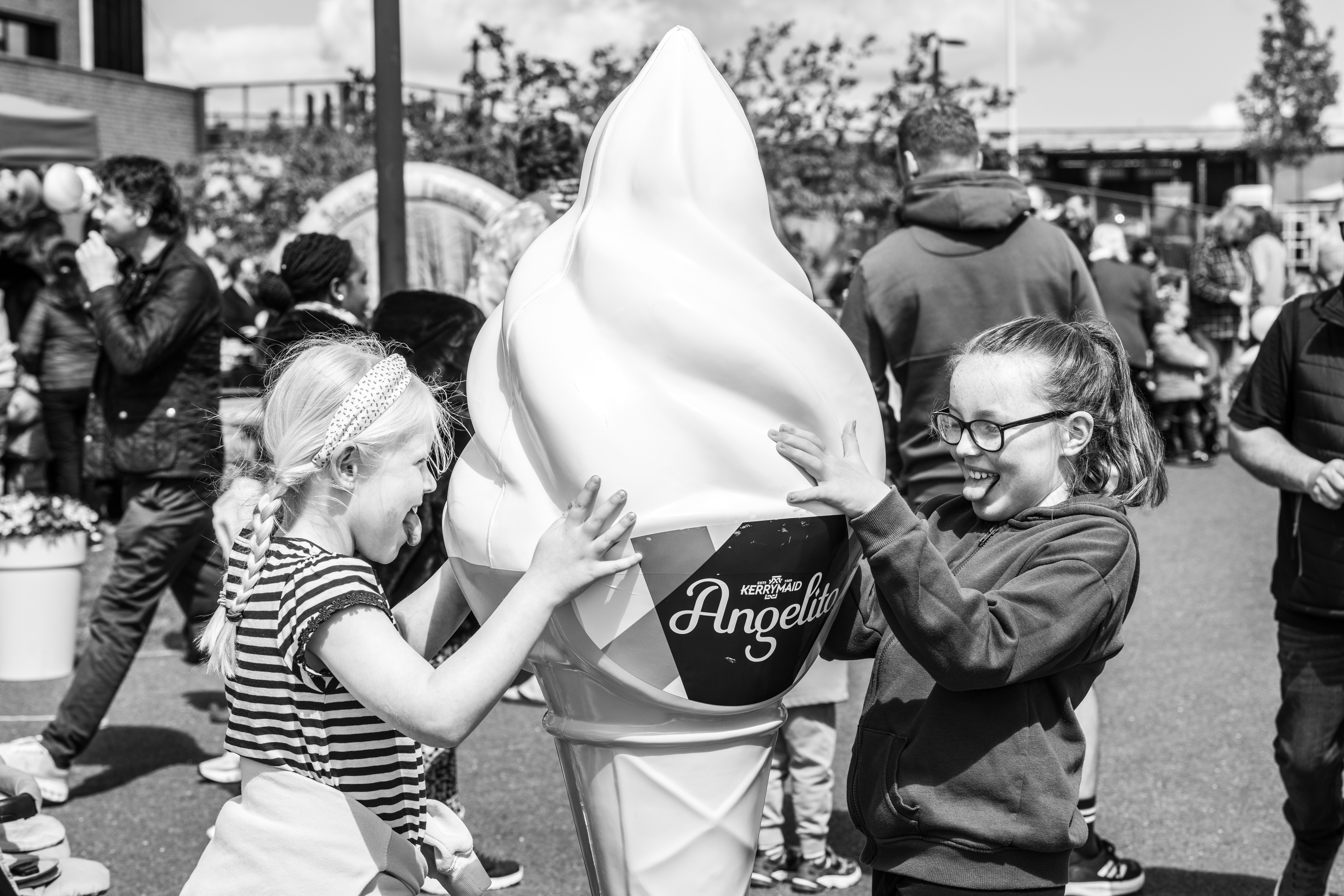 Two children licking ice-cream display. 